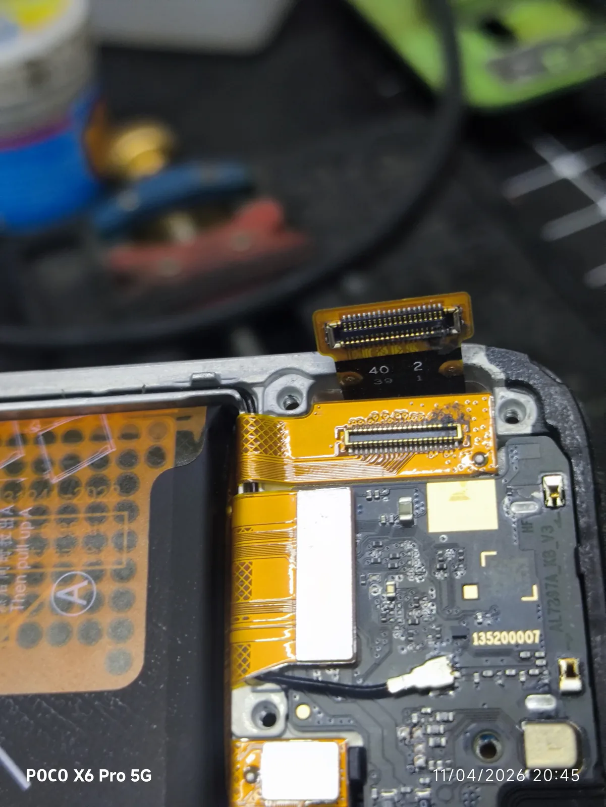 Conector FPC de un celular mojado desconectado de la placa lógica durante el diagnóstico en FixUp Electronics Tonalá