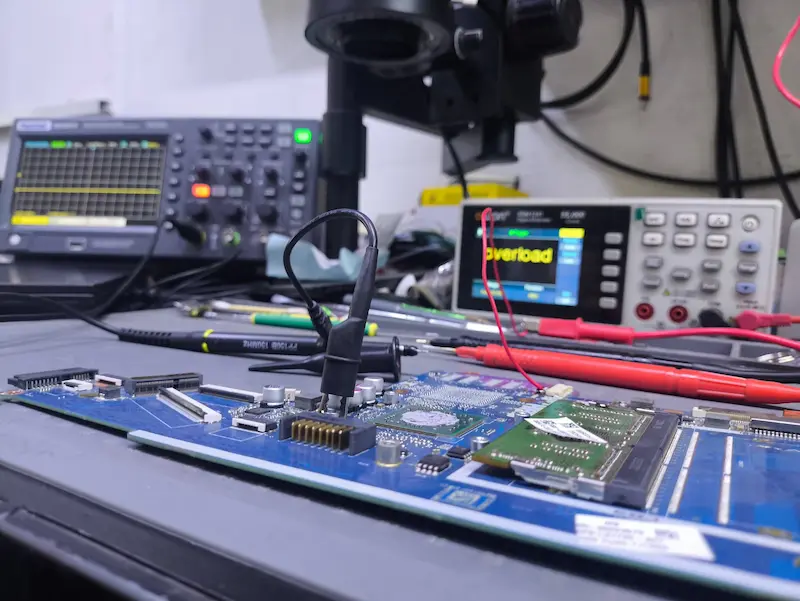 Diagnóstico de laptop con osciloscopio y multímetro en taller Tonalá